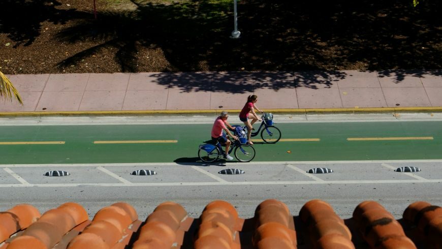 People riding bikes down a street, Ocean Drive, Miami Beach, FL