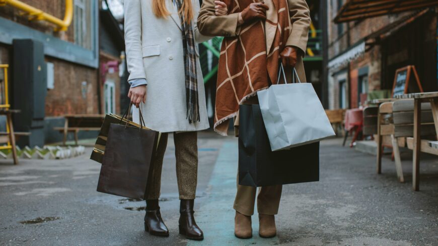 Two women on the street holding shopping bags