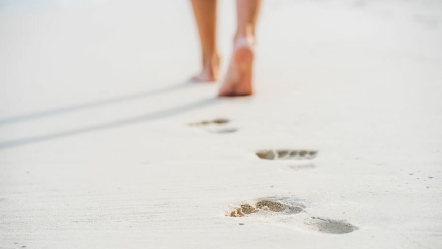 walking barefoot on sand, near the ocean