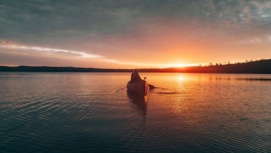 Person on a kayak, sunset, calm river