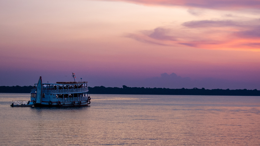Sunset in the river with boat in Amazon Rainforest in Brazil