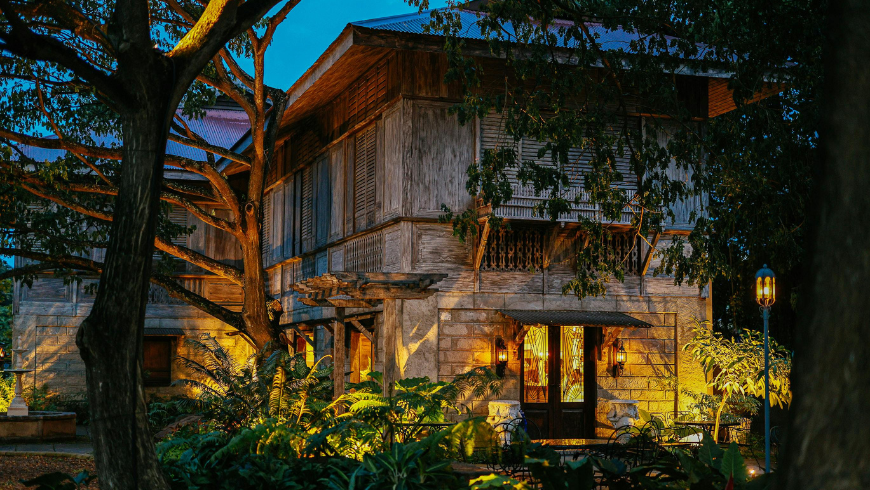 Charming Rustic House at Night with Lush Garden