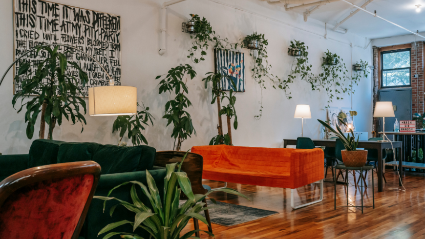 Eco-friendly co-working space with natural light, wooden furniture, and plants, promoting sustainable remote work