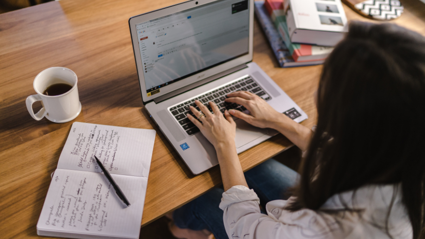 Laptop, notebook and coffee on a table inside an eco-friendly accommodation, representing sustainable remote work