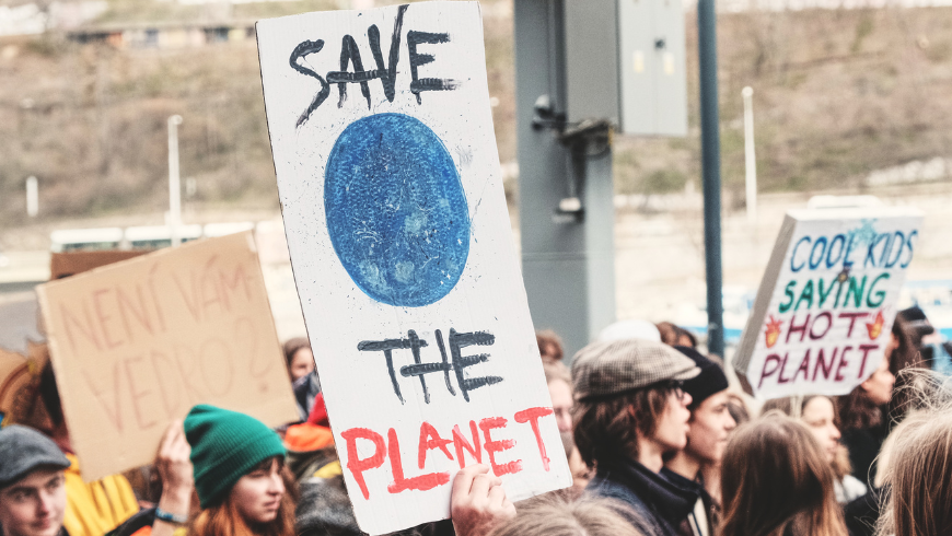 people protesting for climate action and environmental protection holding save the planet sign