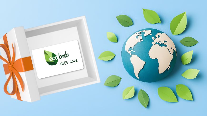 An open gift box with an Ecobnb gift card next to a globe surrounded by green leaves, set against a light blue background.