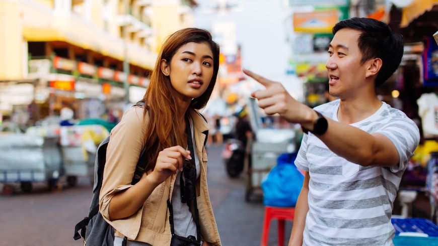 Girl asking for information during a trip, talking to a local person