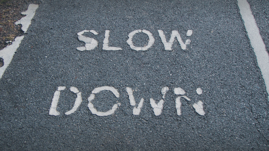 Slow down sign in the pavement 