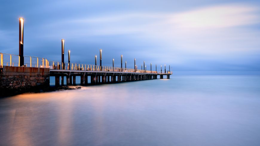 The pier halfway along the beach, during the sunset hour