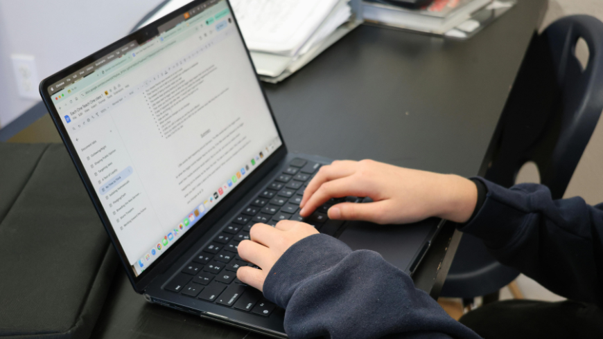 Girl sitting in front of a computer while writing an email.