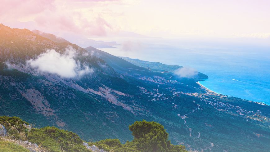 Panoramic view of Llogara National Park in Albania, where dense pine forests meet the rugged mountains overlooking the Ionian Sea.