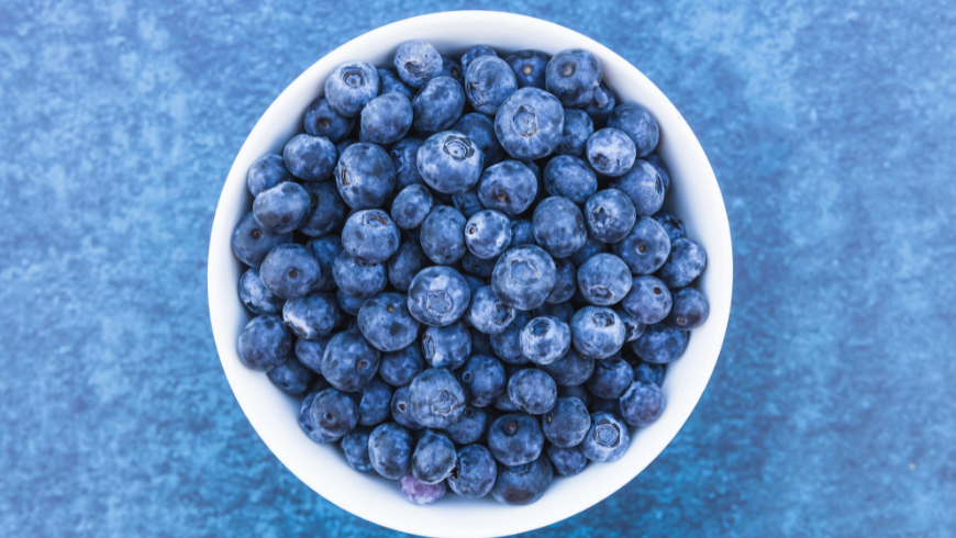 Bowl filled with fresh blueberries, rich in antioxidants and fiber that support a healthy diet and promote satiety.