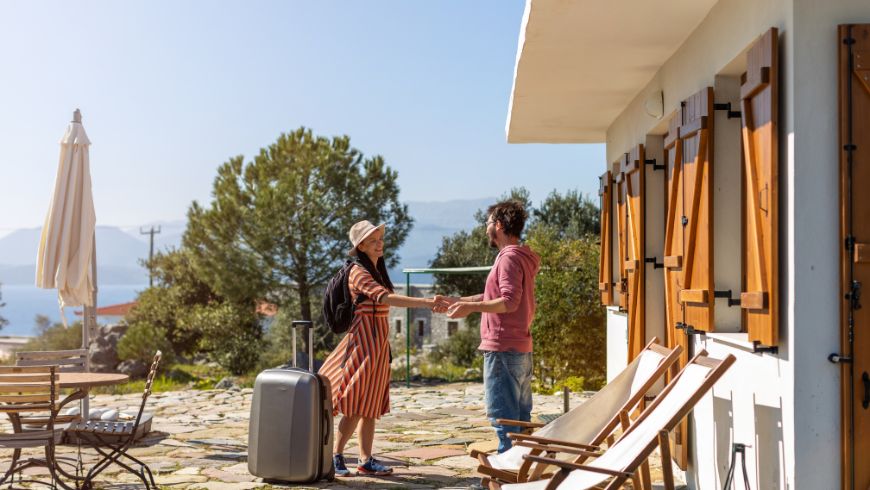 Small accommodation: host welcoming a traveler to her seaside home