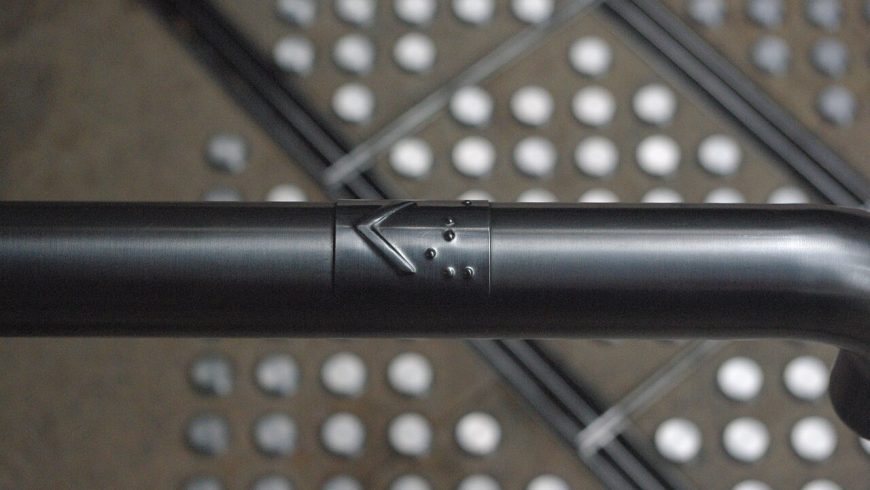 Braille tactile sign on a handrail for accessible wayfinding