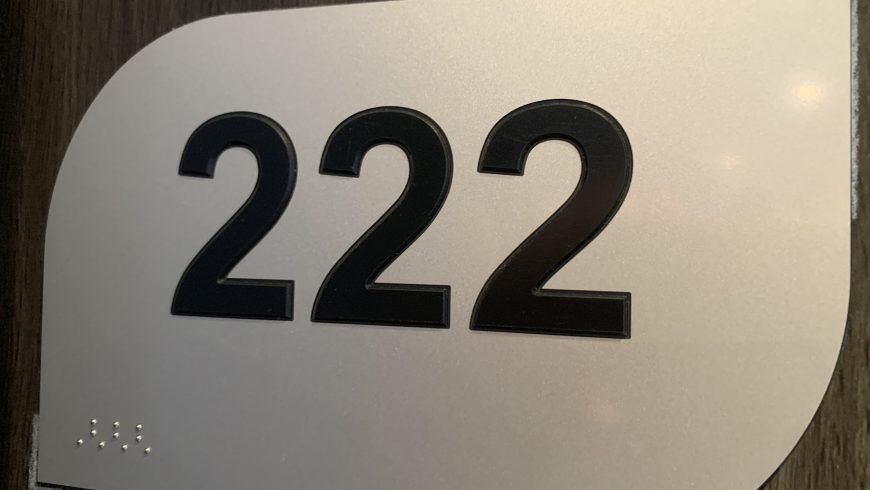 Hotel room door with tactile room number and Braille signage