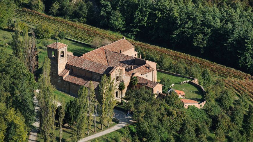 Aerial view of Vezzolano Abbey, surrounded by greenery and connected to the Romanesque walking routes