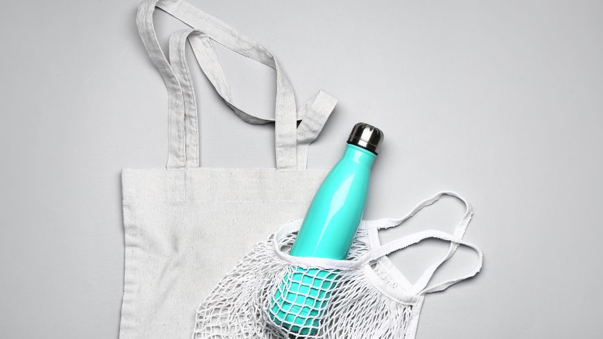 Reusable water bottle and cloth bag for a more sustainable trip.