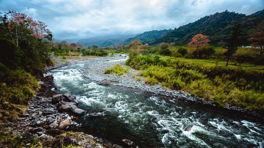 River flowing through the lush green landscape of the Orosi Valley in Cartago Province, Costa Rica.