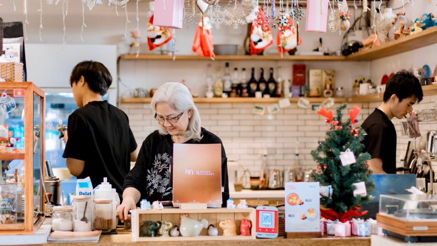 a cozy cafe decorated for the holidays, with staff busy behind the counter