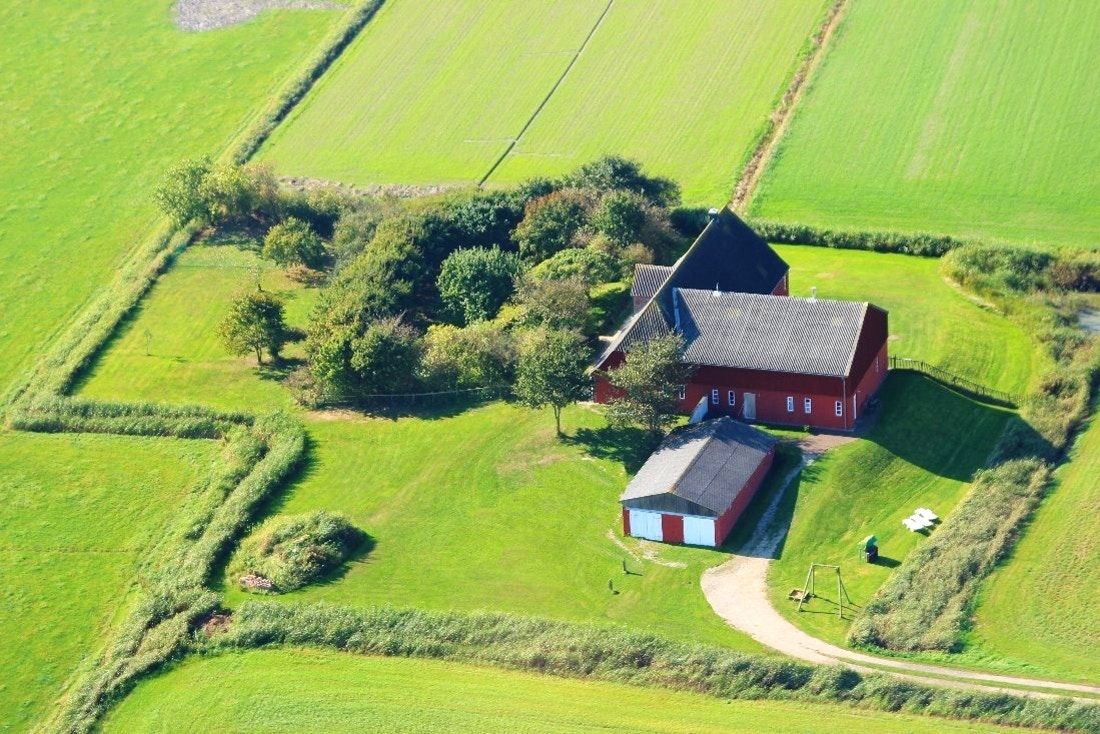 Eine rote Norseeinselfarm umrandet von Feldern von oben