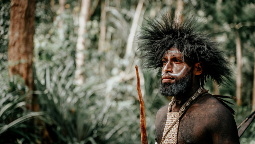 Indigener Mann mit traditioneller Gesichtsbemalung im Dschungel