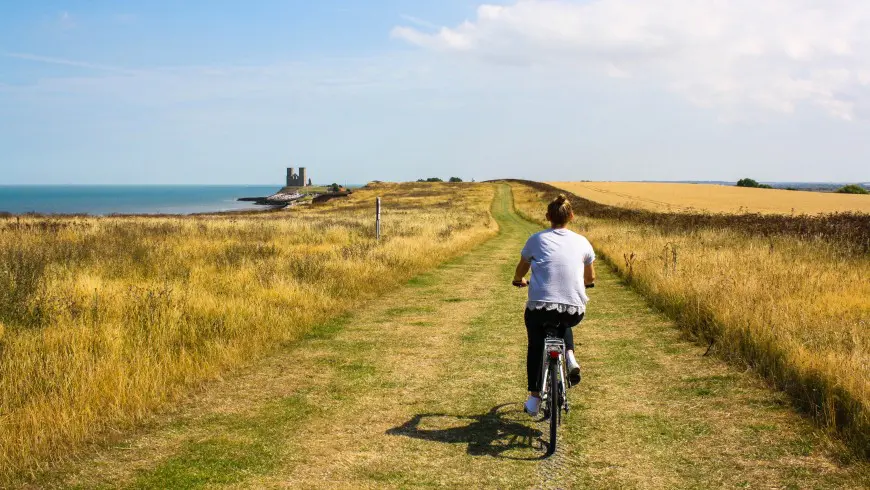 Radfahrer auf einem Weg durch eine offene Landschaft.