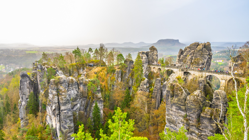 Basteibrücke in der Sächsischen Schweiz mit markanten Sandsteinfelsen und grüner Vegetation.