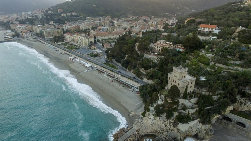 Blick auf den Strand von Finale Ligure mit dem blauen Meer und der Stadt
