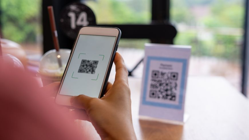 Gast scannt einen QR-Code mit dem Smartphone