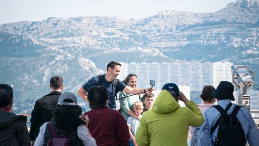 Touristen machen Selfies vor einer beeindruckenden Berglandschaft