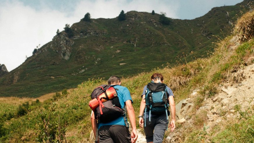Zwei Reisende wandern durch eine ruhige Naturlandschaft