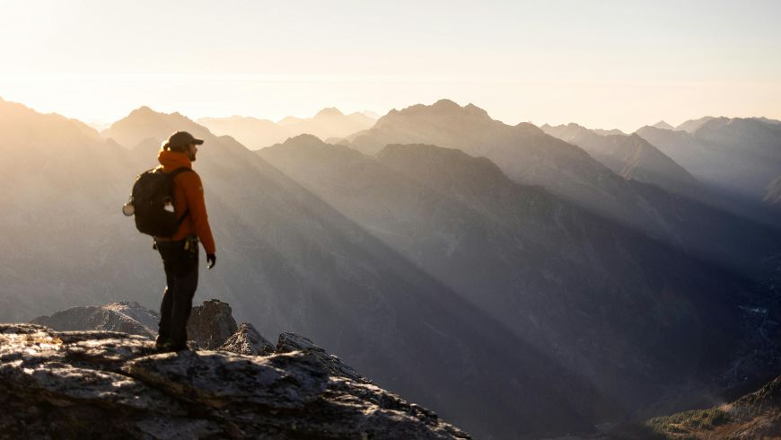 Eine Person wandert durch die Natur und genießt den Ausblick auf die Landschaft.