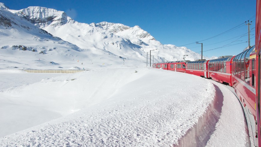 Paisaje de las montañas en invierno en medio de la nieve donde cruza el tren Rojo de Bernino en Suiza