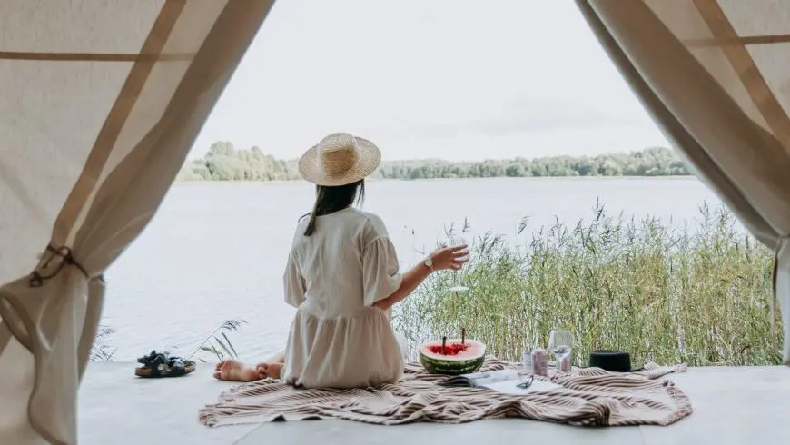 femme assise regardant le lac devant elle.