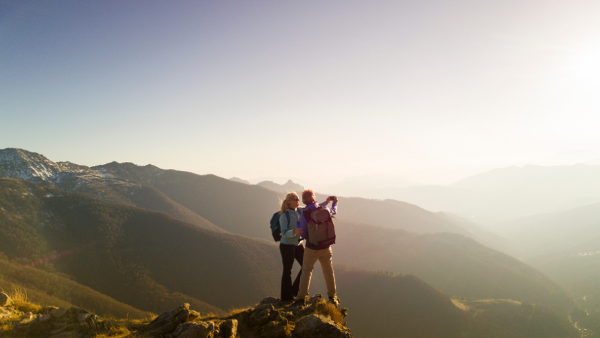 Un couple sur une montagne regardant le paysage.