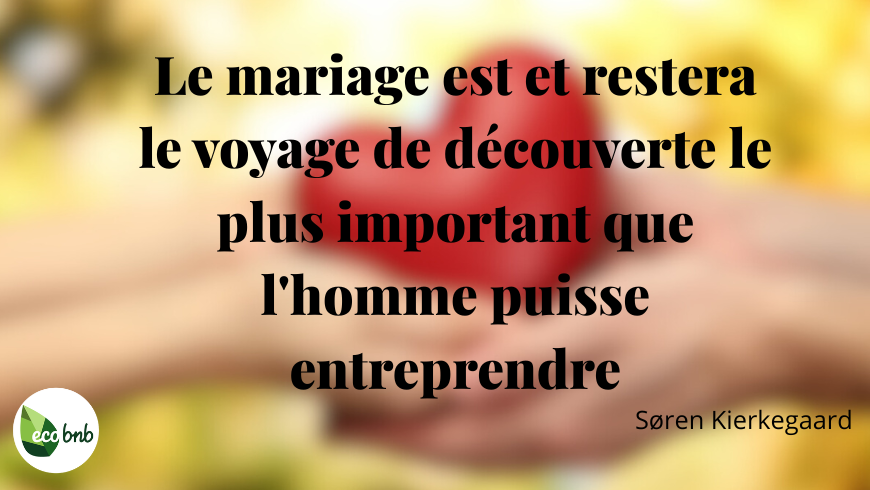 Citation sur le mariage de Søren Kierkegaard en typographie noire élégante sur un fond chaud et légèrement flou, avec un cœur rouge tenu entre deux mains, accompagnée du logo Eco BnB.